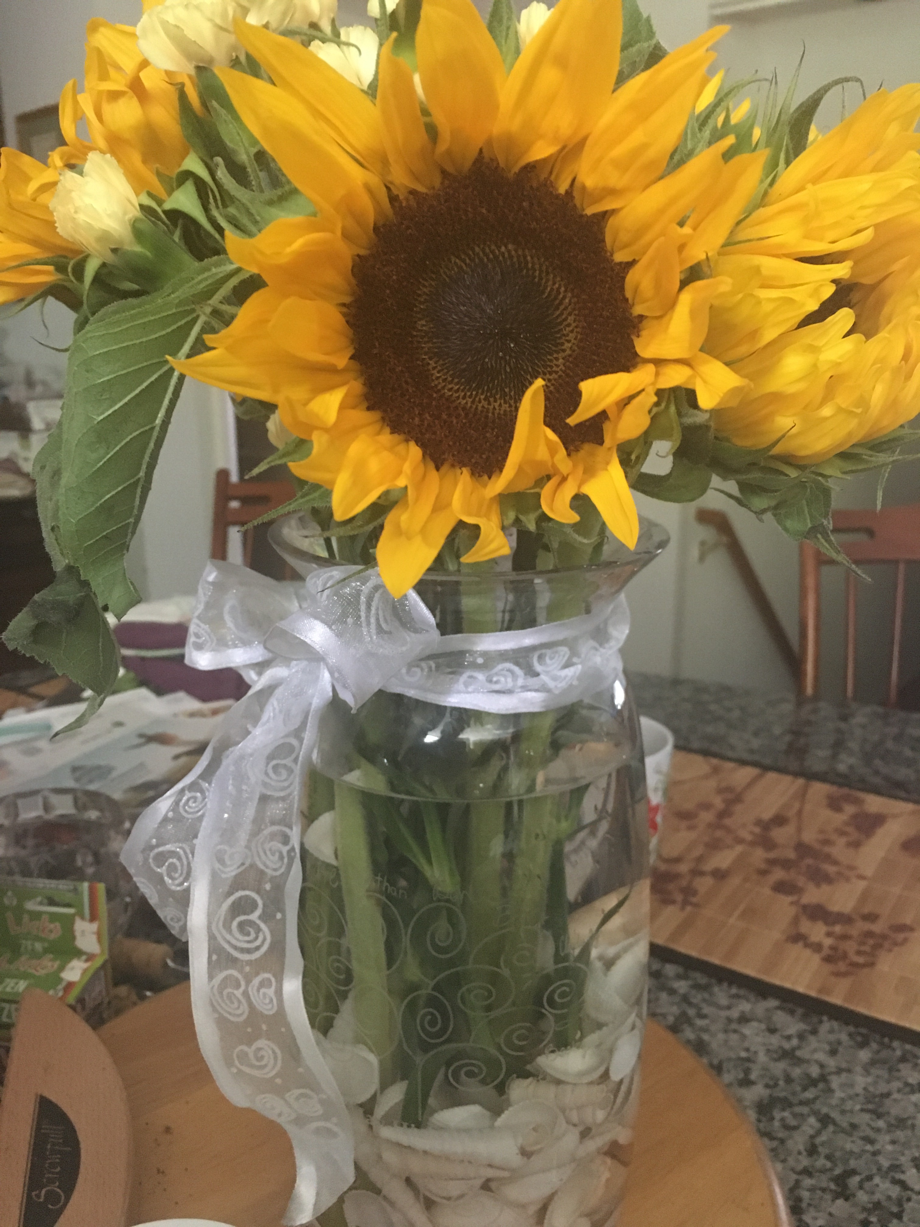 Sunflowers and miniature carnations in a large crystal vase  
