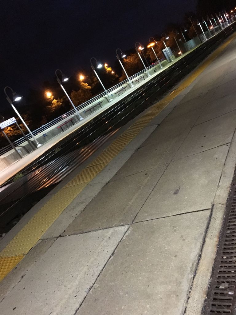 an empty train station platform in pre-dawn darkness