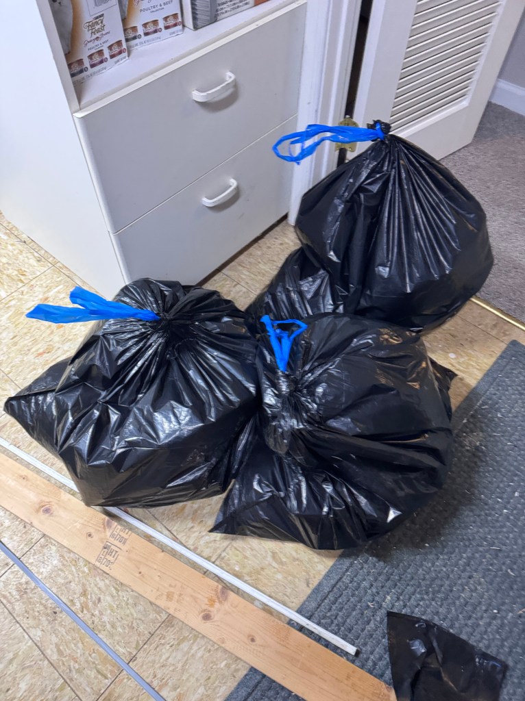 Garbage bags full of defrosted food from a freezer.